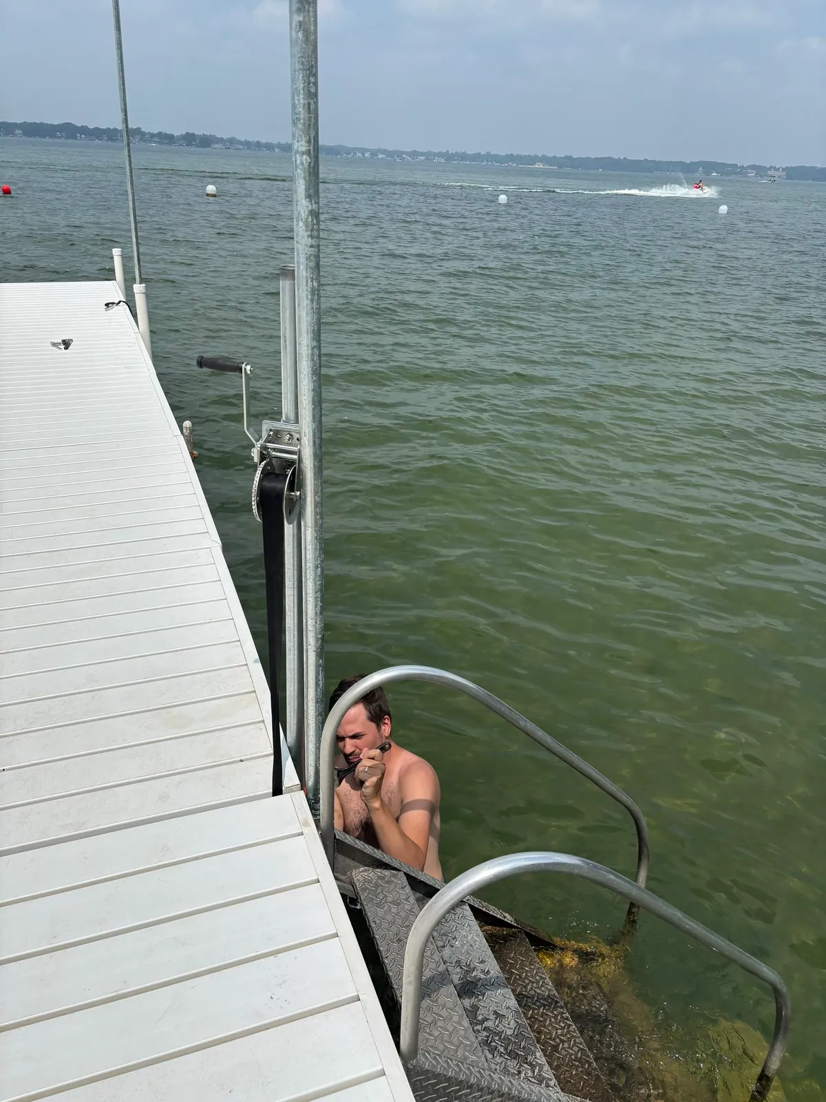 Installer working from the water beside the DockShade pole and furler hardware