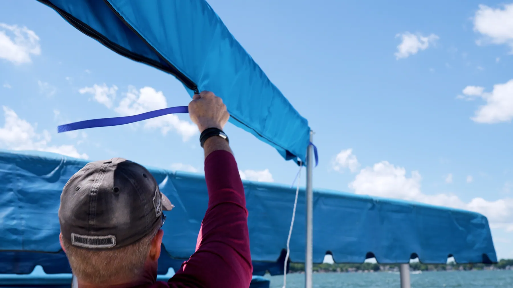 Installer closing the fitted blue zippered cover around a furled DockShade